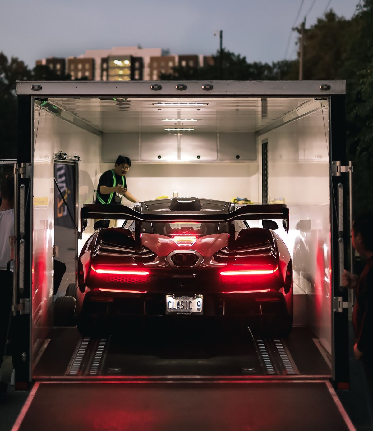An exotic car being loaded into an enclosed transport trailer